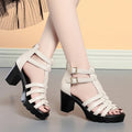 Women's beige high heel shoes with hollow-out design and rhinestone decoration on the upper.