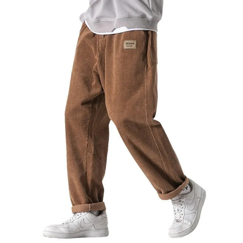 Men's loose straight-leg corduroy sports trousers in army green, laid flat to show fit and texture.