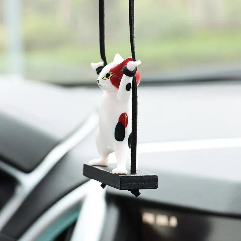 Cartoon-style resin cat pendant for car interior decoration with adjustable rope.