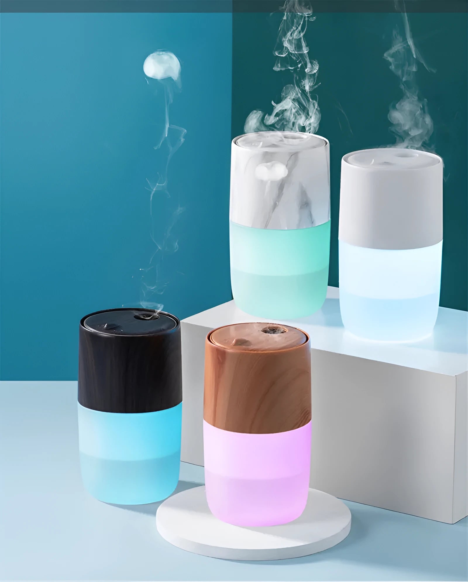 Mini portable jellyfish-shaped ultrasonic humidifier in black, with USB cable and essential oil bottle on a desktop