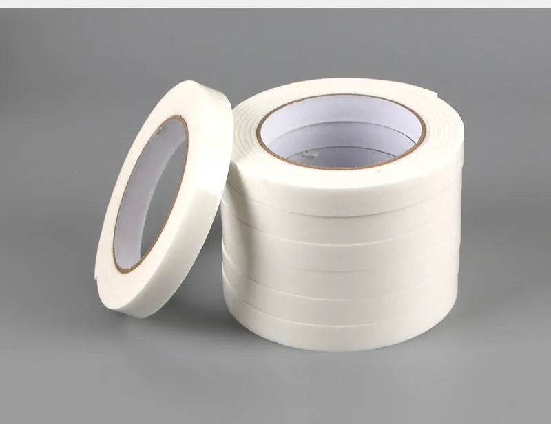 Roll of 3mm thick white foam double-sided adhesive tape showing its spongy core and strong adhesive on both sides.