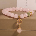 Pink crystal four-leaf clover pendant bracelet for women with rhinestones on alloy band.