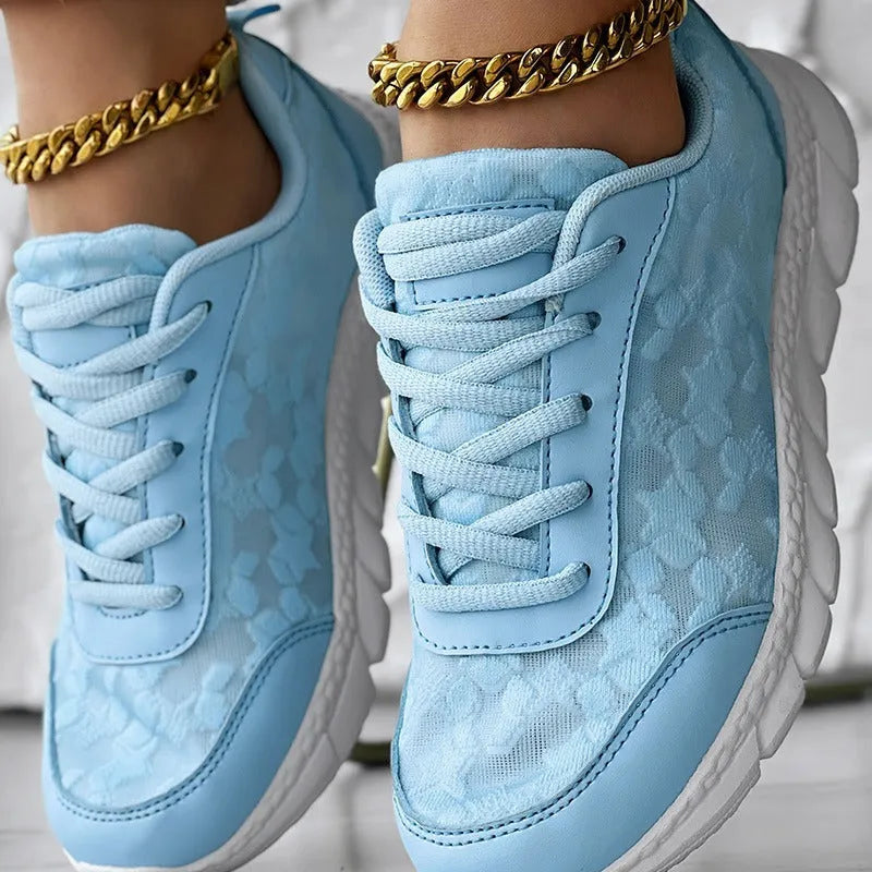 Women's white canvas sports running shoes with flat heel and round toe on a plain background.