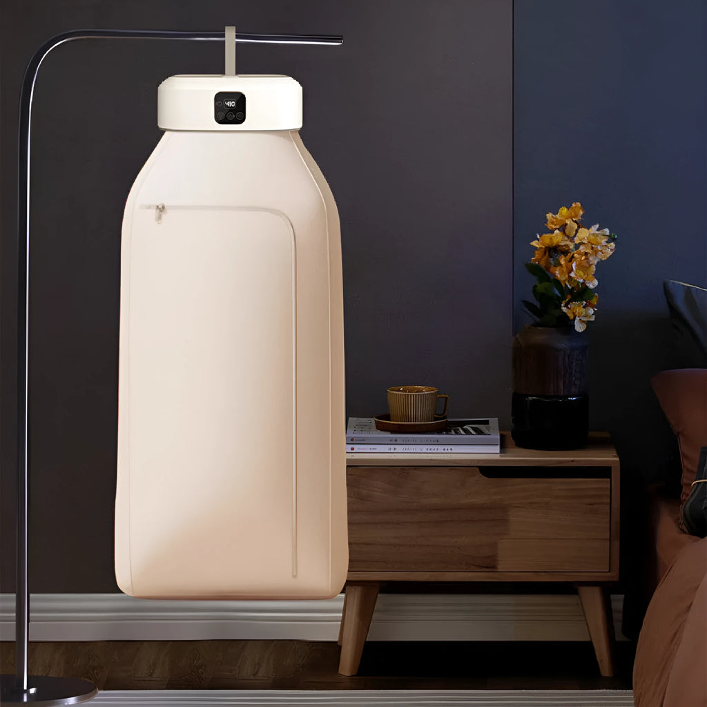 White cylindrical foldable portable clothes dryer with remote control on wooden surface