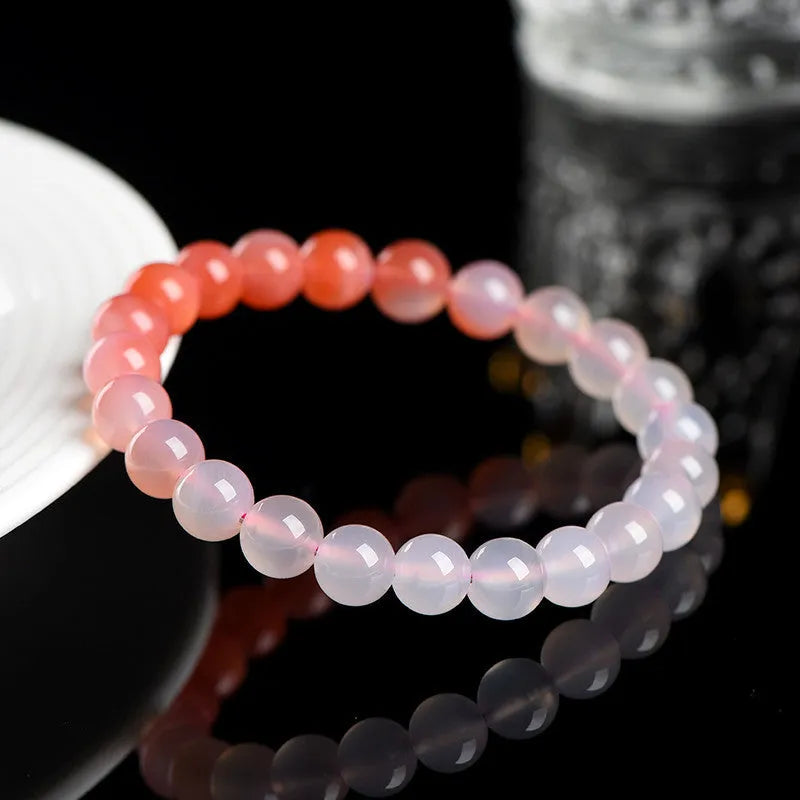 A gradient coloured Yanyuan agate bracelet with polished geometry-shaped beads on a white background.