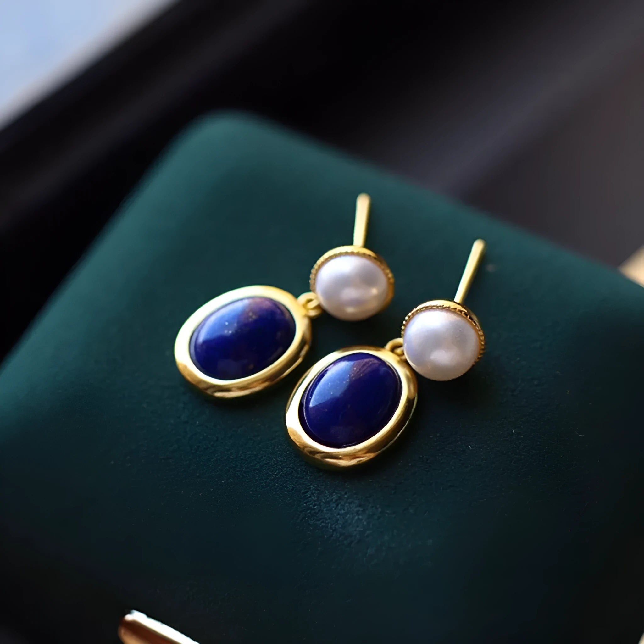 A pair of simple 925 silver drop earrings with a blue lapis lazuli pearl and auspicious patterns.