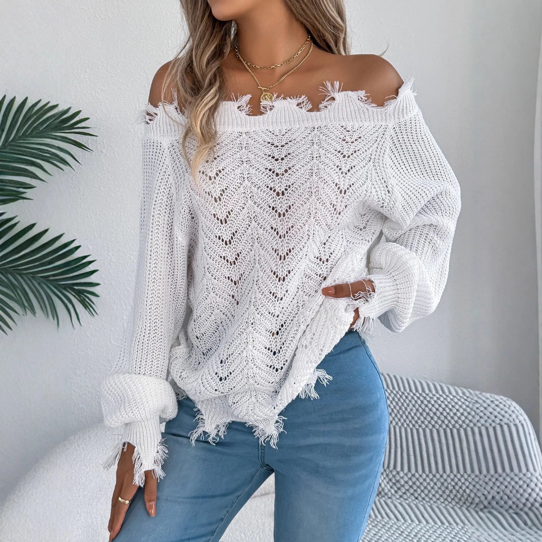 White hollow-out cut off-the-shoulder acrylic wool pullover sweater on a hanger.