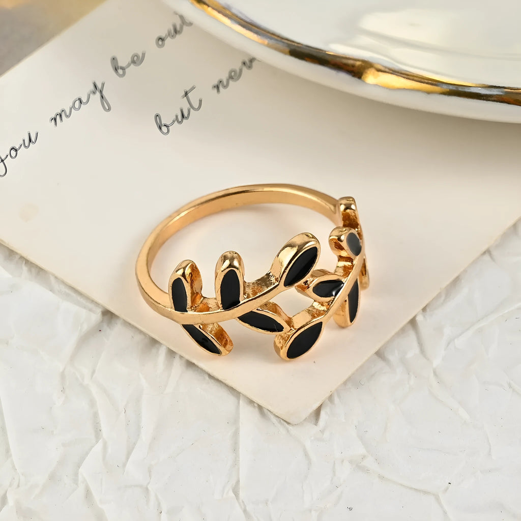 Gold geometric leaf acrylic ring for women on an index finger.