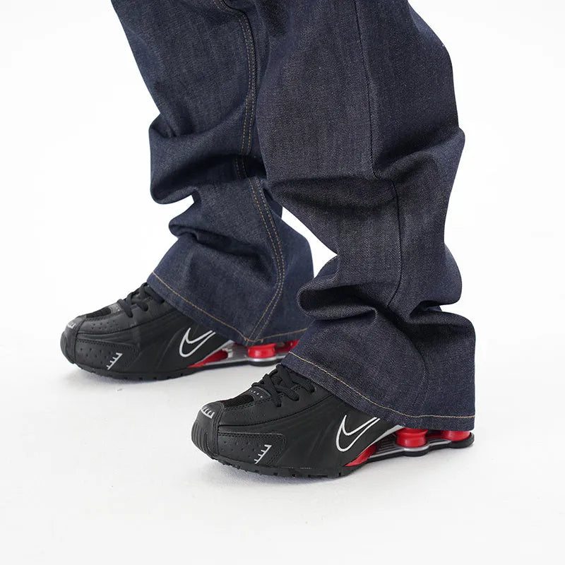 Man wearing dark blue loose straight-leg casual jeans.