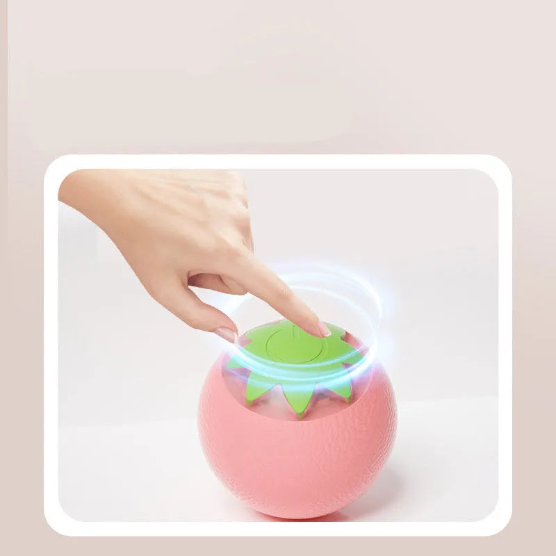 Small green automatic rolling ball toy for dogs and cats on a wooden floor.