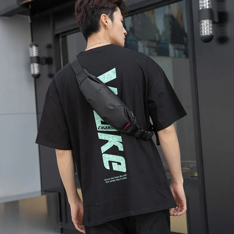 Black Oxford cloth crossbody waist pack for men showing front zipper and internal phone pocket.