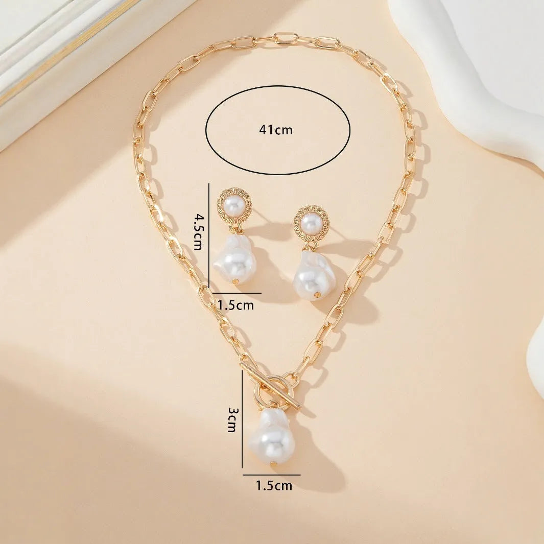 Gold colour baroque pearl necklace and earring set with retro design on dark background