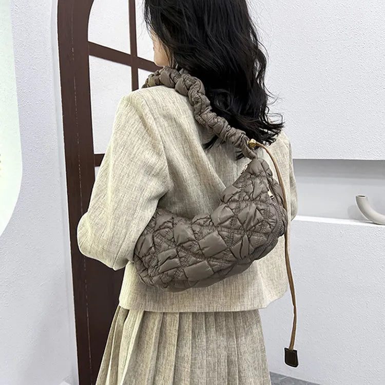 Women's solid colour nylon messenger bag with long shoulder strap shown in beige.