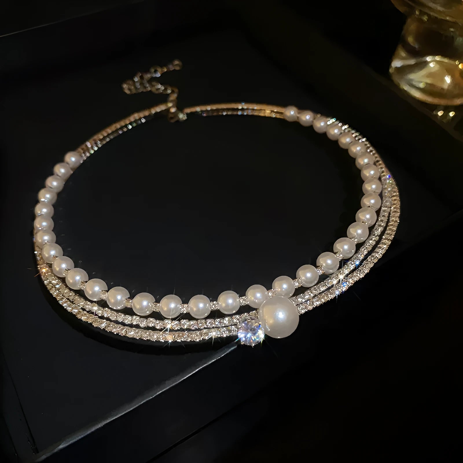 Close-up of a women's geometric necklace with a round curved silver pendant on a clavicle chain.