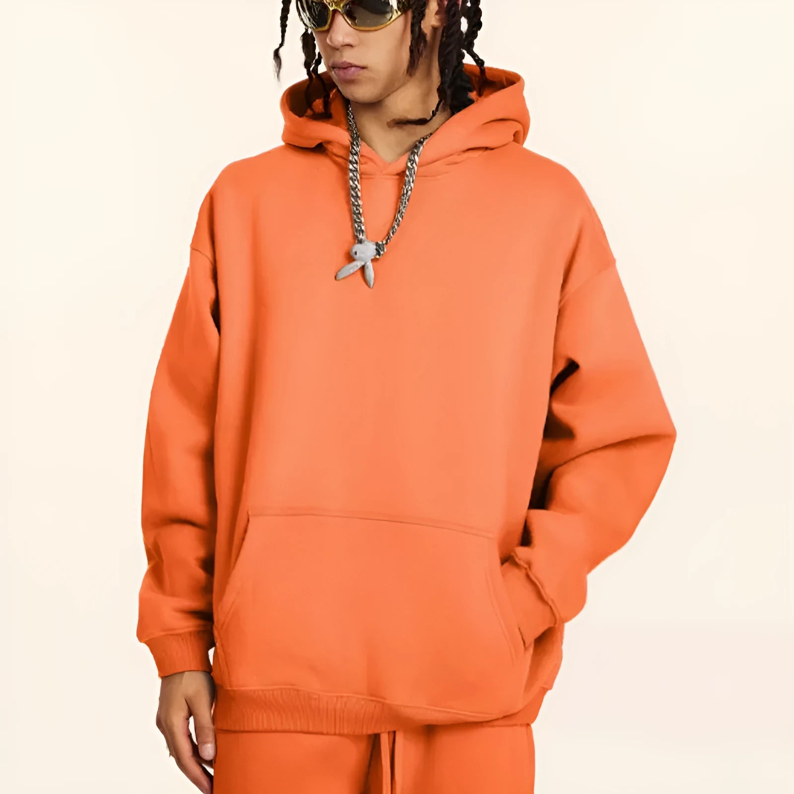 Man wearing a loose grey cotton terry hooded sweater with drop-shoulder sleeves