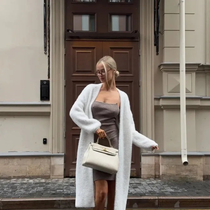 White knit cardigan jacket with extended length on hanger