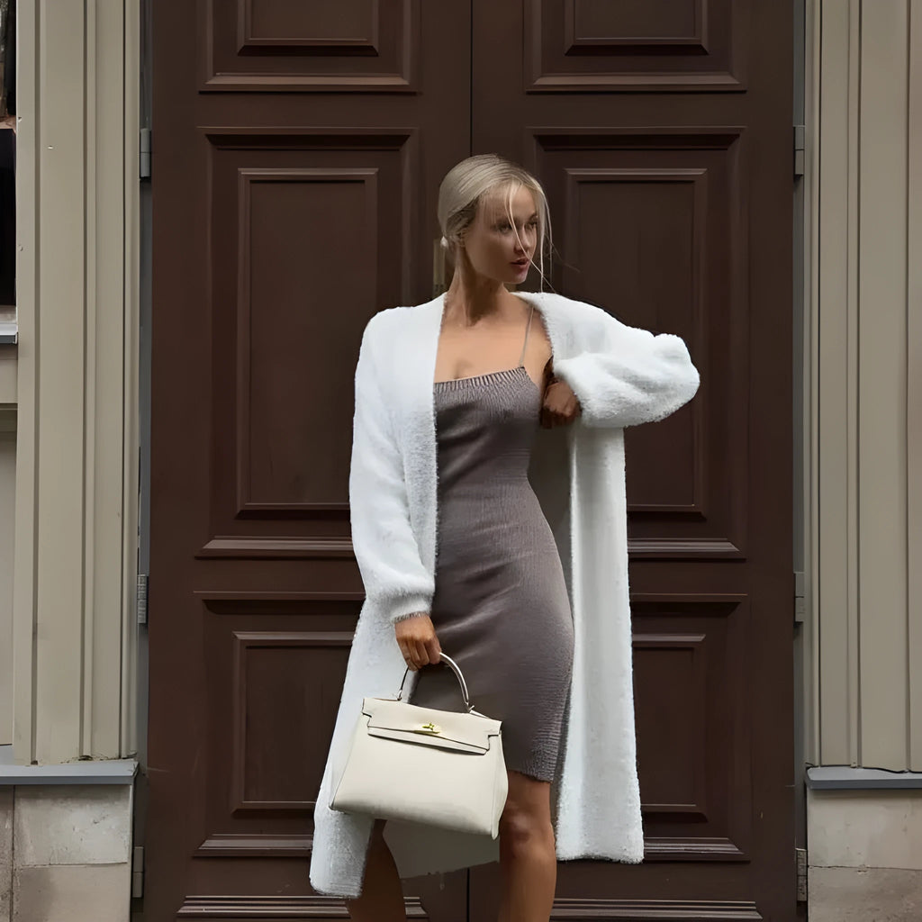 White knit cardigan jacket with extended length on hanger