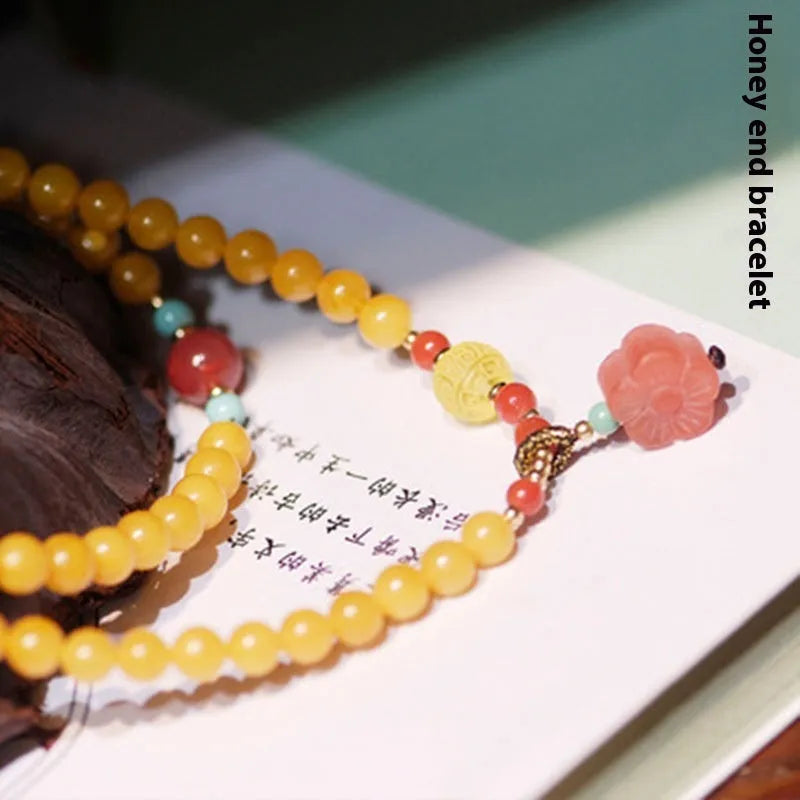 Yellow amber bracelet with 5mm round shape and animal zodiac design in retro style.