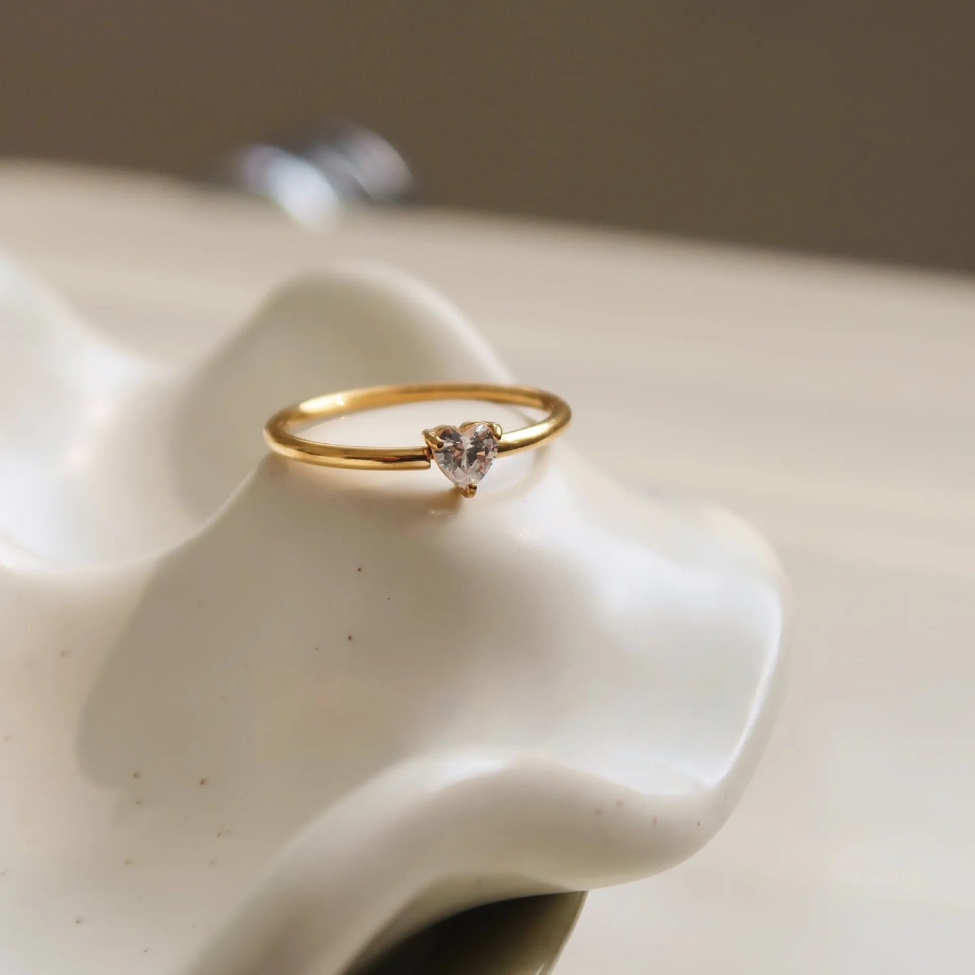 Golden heart-shaped stainless steel ring on a white background, showing its simple bracelet design and electroplated finish.