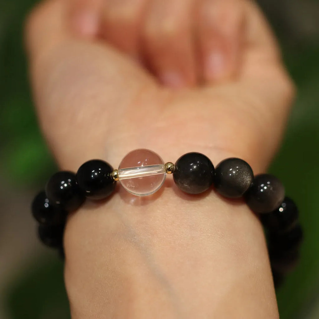 Chinese style geometric crystal bracelet with cat eye obsidian effect and auspicious patterns.