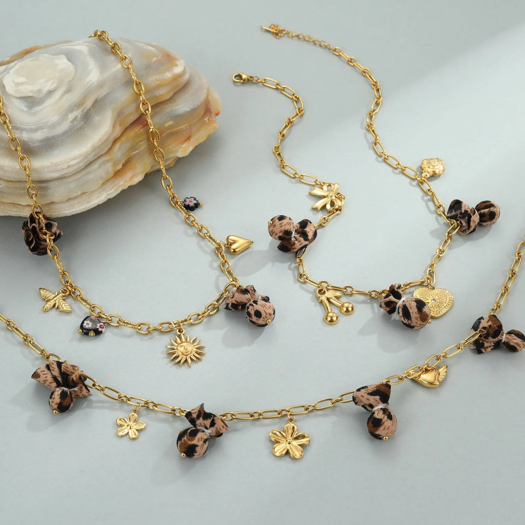 Gold plated stainless steel necklace with geometric leopard, heart, and flowers pendant on adjustable chain