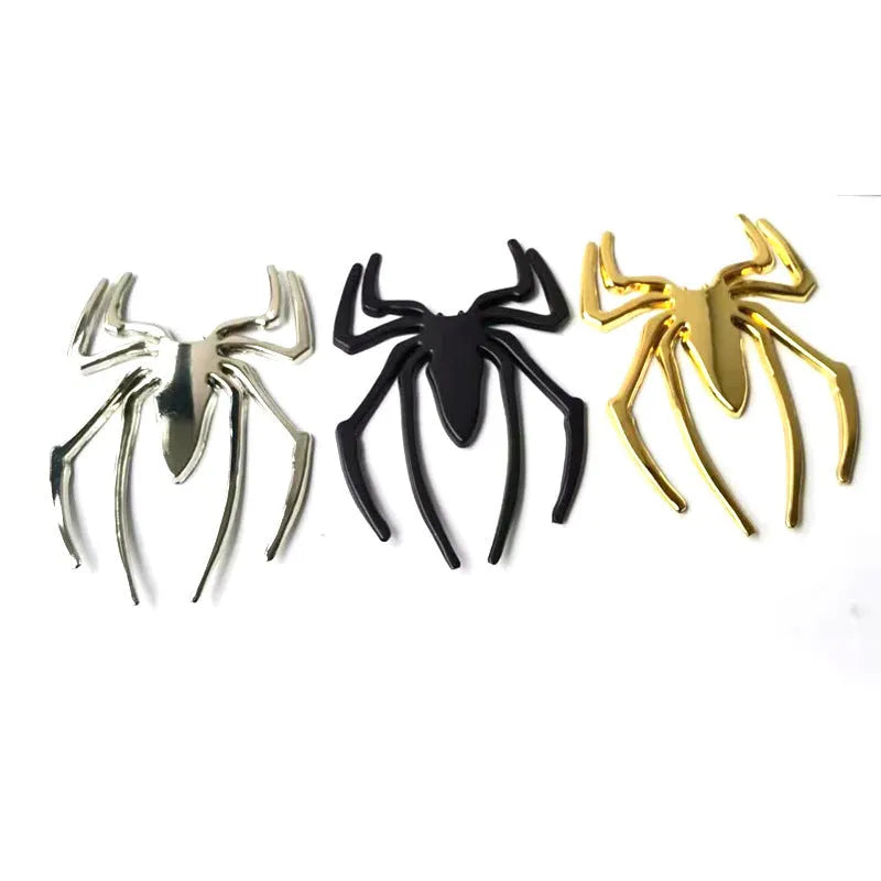 Three-dimensional metal spider bumper sticker in zinc alloy, shown in gold colour, measuring 7 by 5 cm.