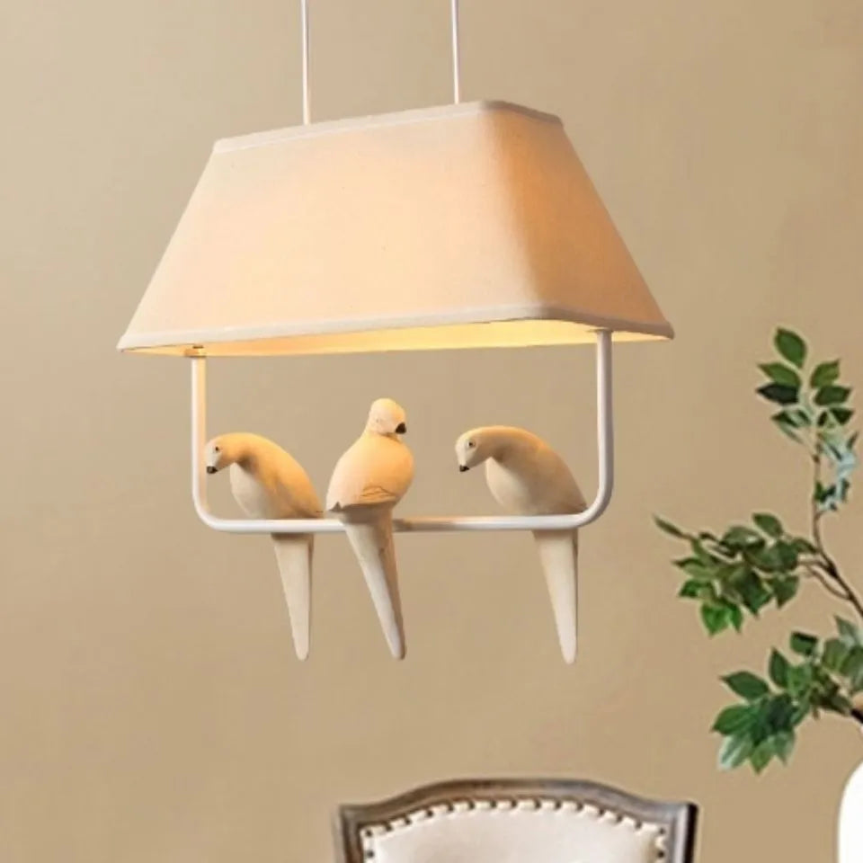 Iron ceiling chandelier with fabric shades featuring bird designs, hanging as a droplight.