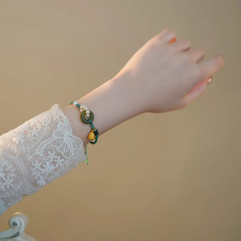 Hand-woven women's watch band with a pearl peace buckle closure on a flexible wire bracelet.