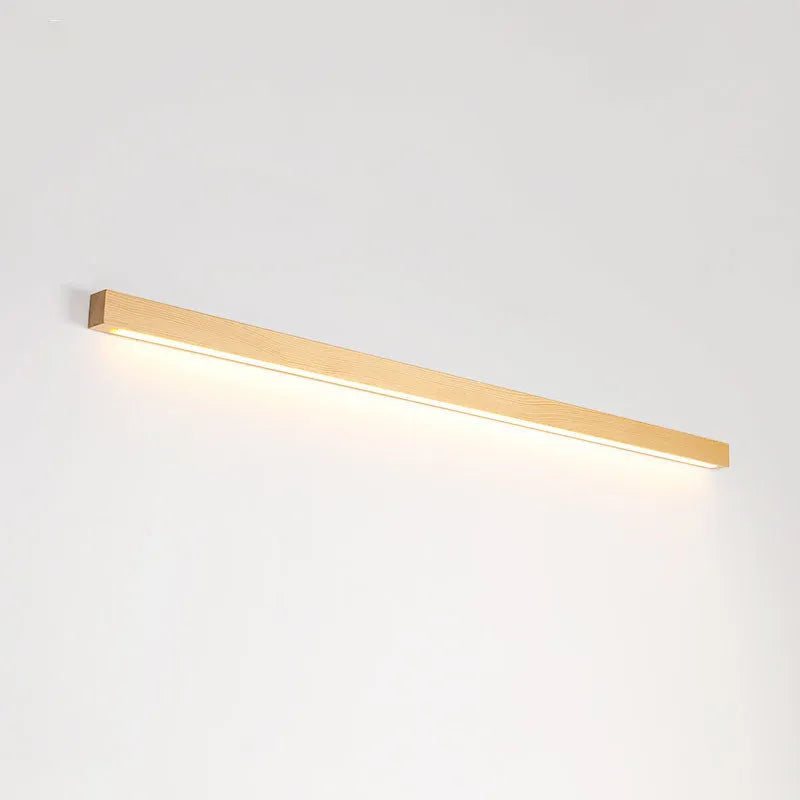 Slim walnut-coloured wood and acrylic LED strip wall lamp mounted on a wall in a modern room.