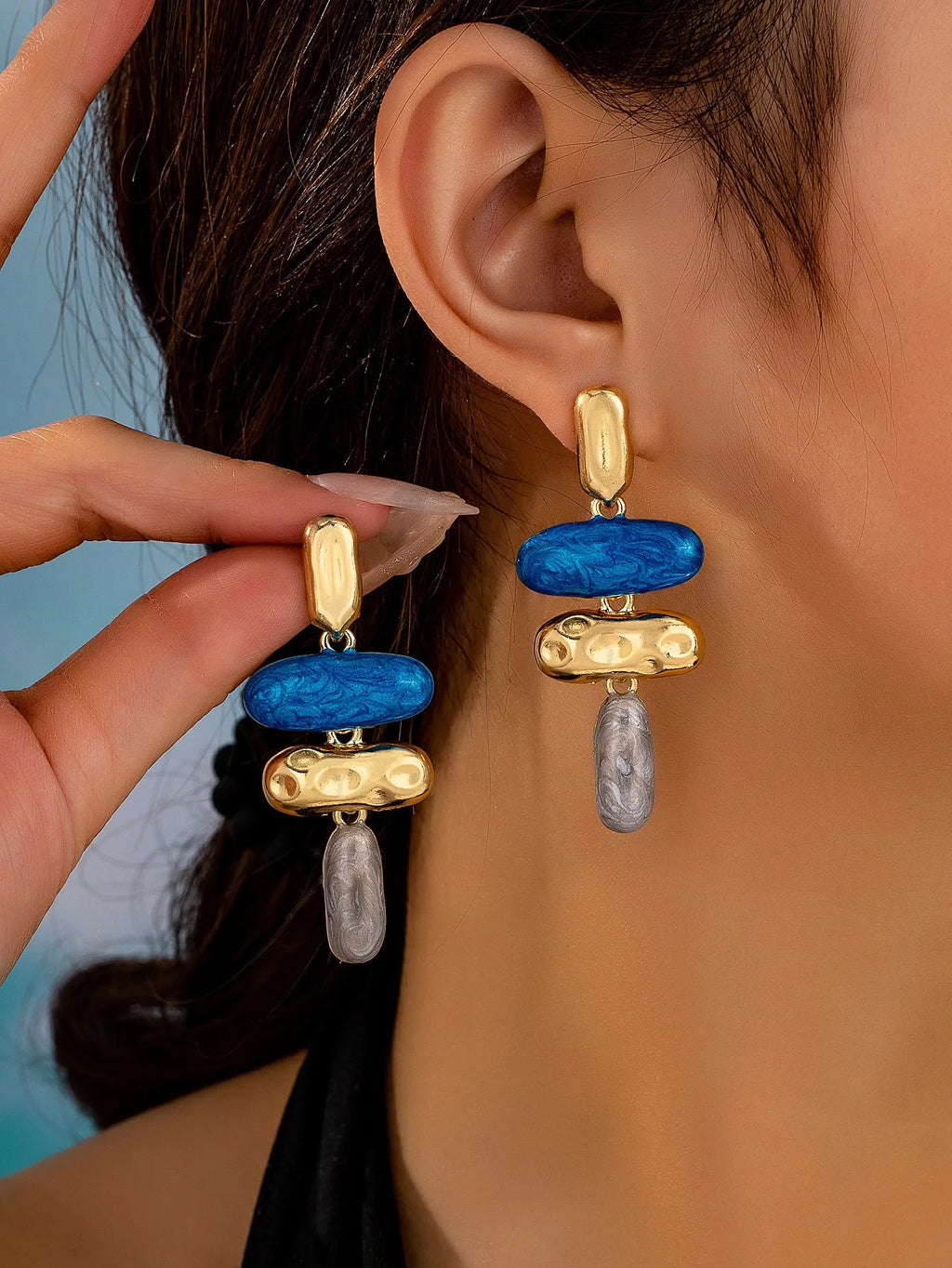 A pair of geometric-shaped stud earrings with a multicolour electroplated metal finish.