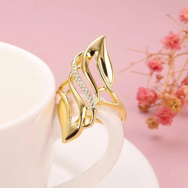 Women's copper ring with exaggerated curved design and gold-coloured finish showing side profile