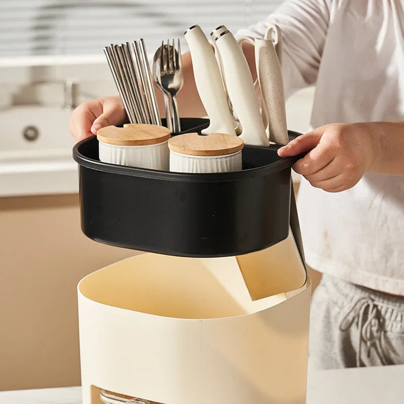 White rotating kitchen storage bucket with attached four-compartment spice box for utensils and seasonings.