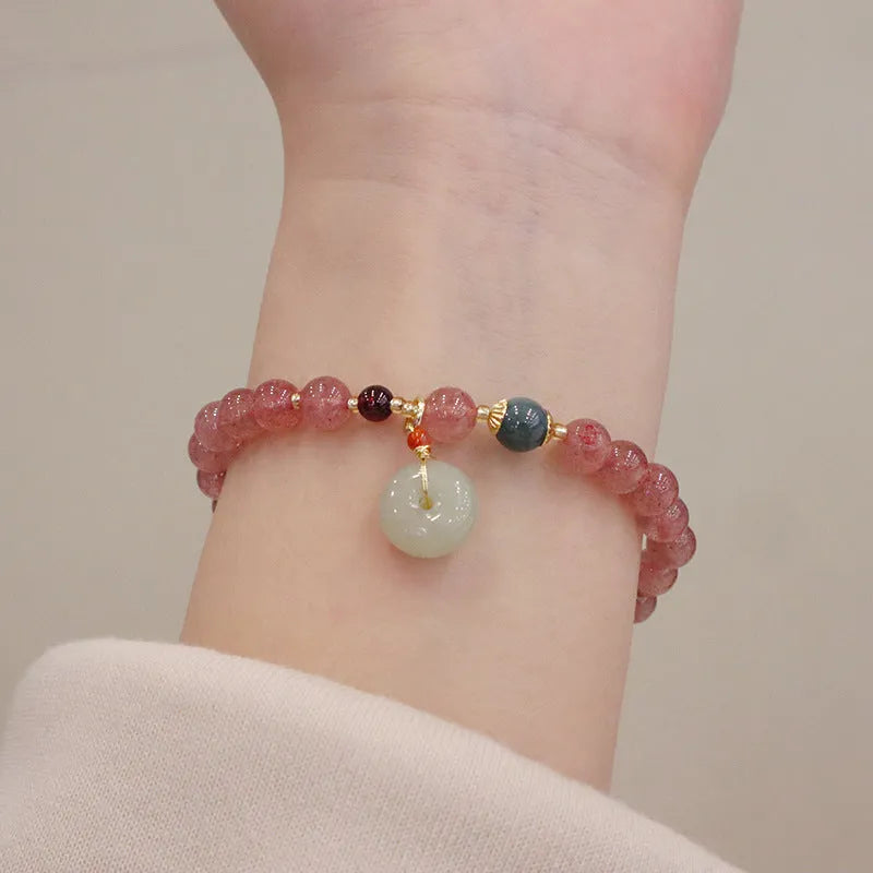 Natural strawberry quartz women's bracelet with geometric design, peace buckle closure, and lucky bagg purse charm attachment