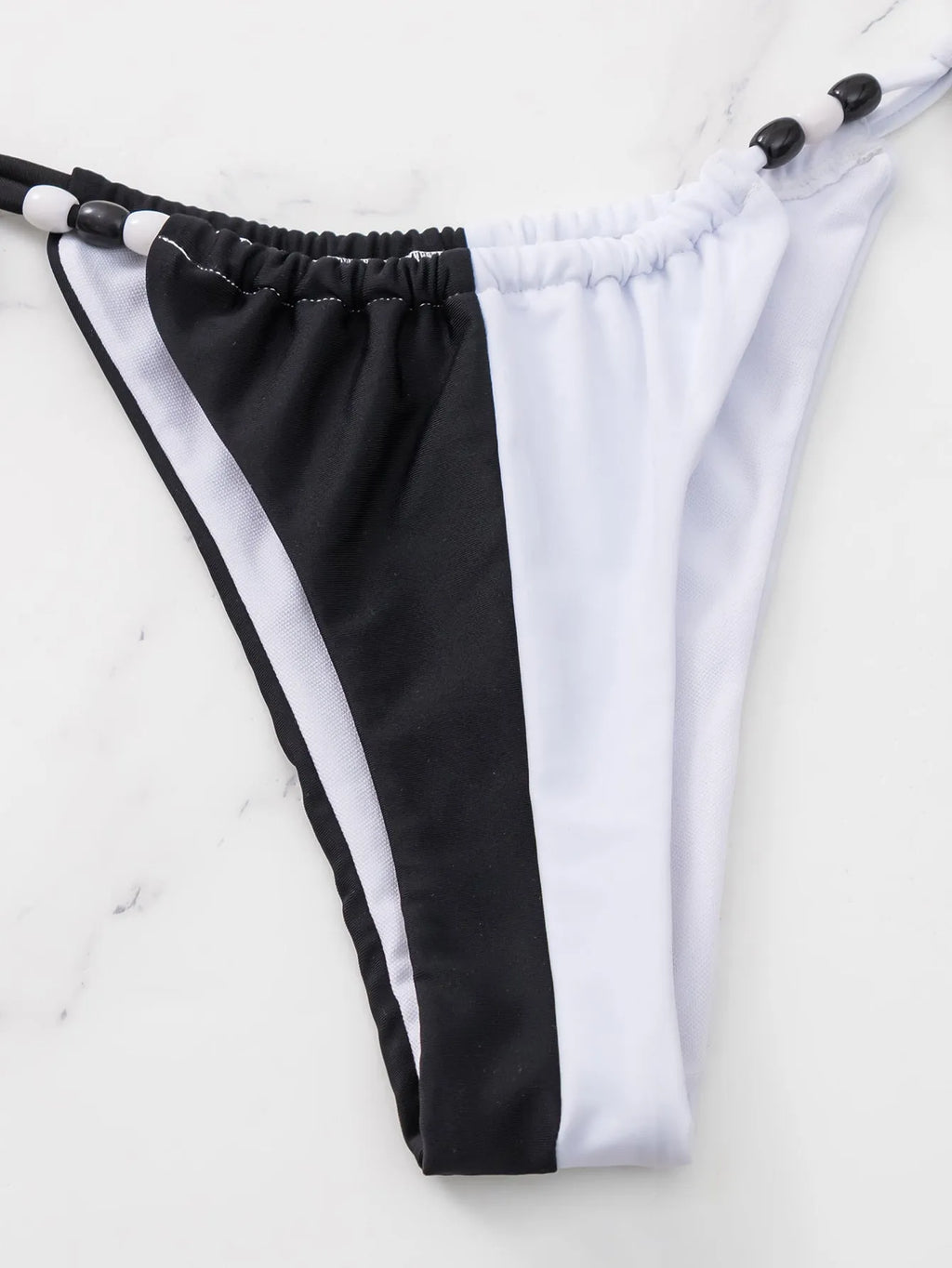 Black and white women's bikini set with lace-up front on triangle cup top and high-waist briefs.