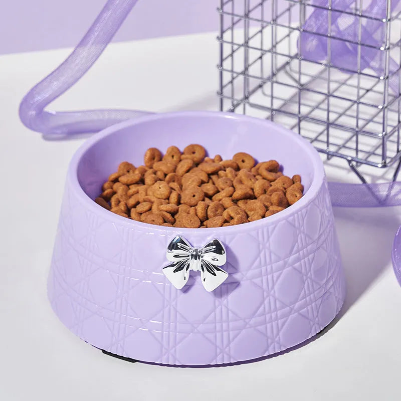 Set of four pet food bowls with bowknot design and diamond pattern in pink, silver, black, purple, and white colours.