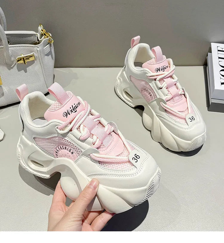 Women's pink sneakers with thick soles, cross shoulder straps, and a breathable mesh lining on a white background.