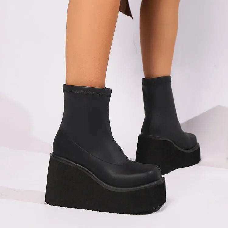 Black plus size women's ankle boots with a wedge heel and round toe.