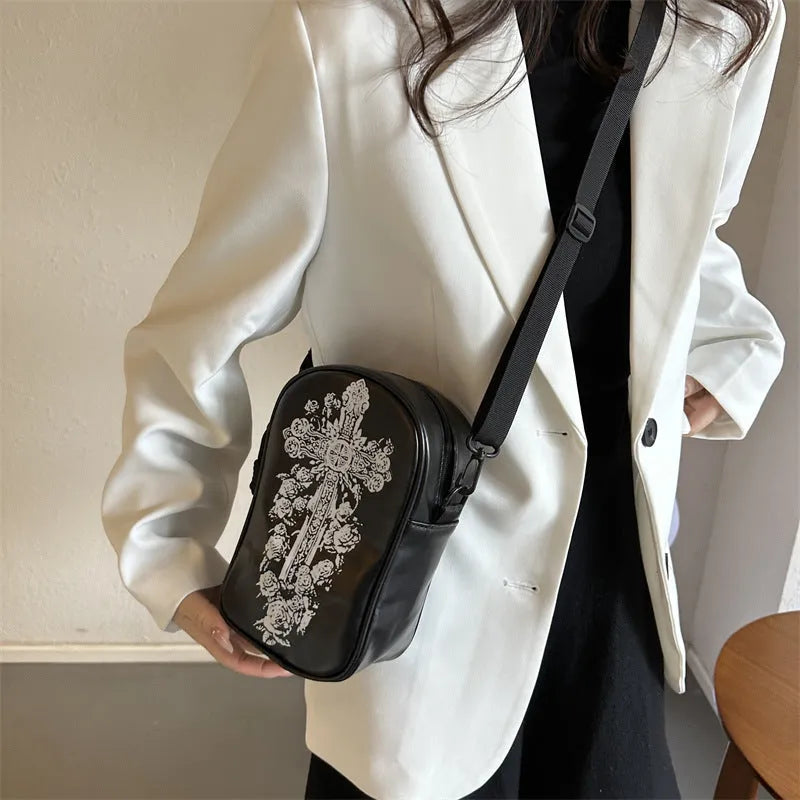 Black Halloween crossbody bag with graffiti print of cartoon pumpkins, ghosts, and bats.