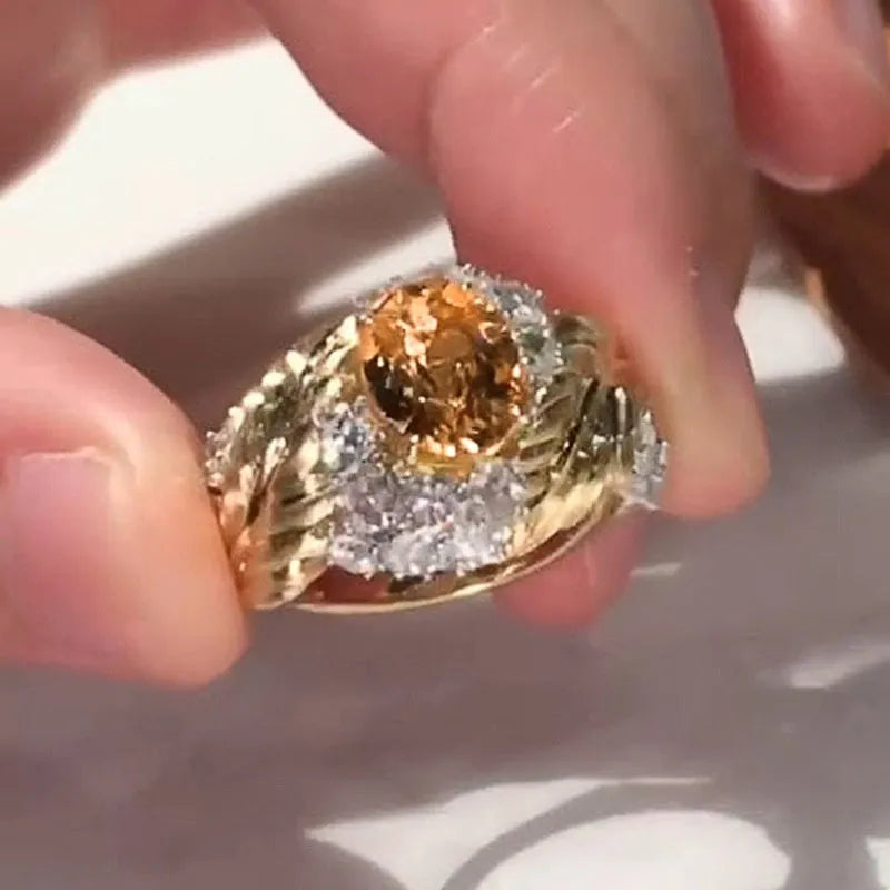 Gold-coloured copper ring with embossed feather design and inlaid yellow zircon stones.