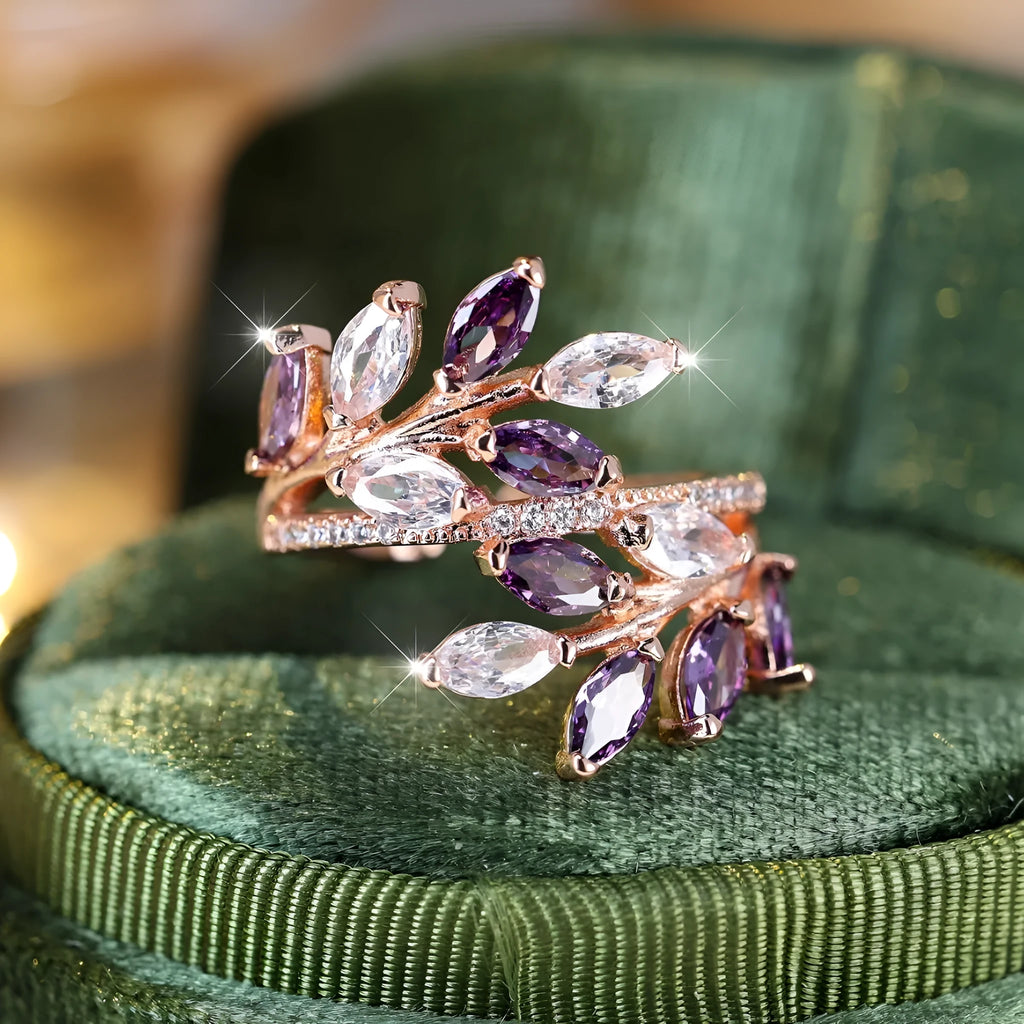 Adjustable copper leaf-shaped ring with zircon stones in various colour options on a white background.