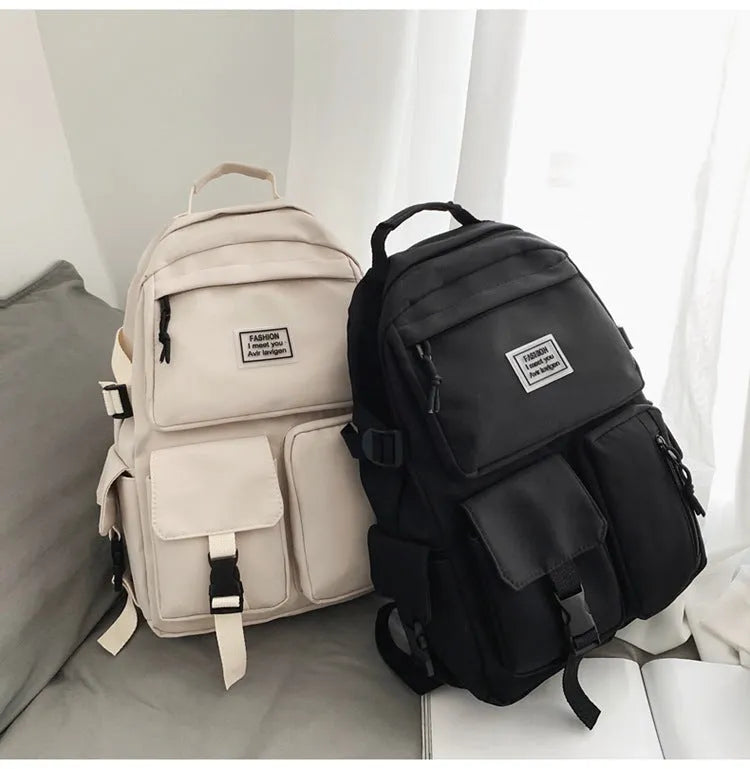 Black and white nylon student backpack with front pockets and laptop compartment.