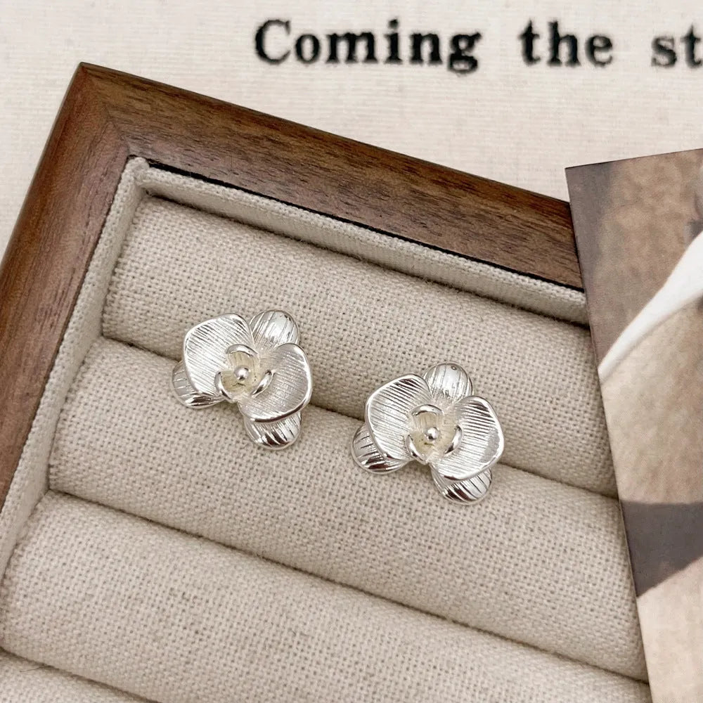 Retro style flower earrings for women in gold or silver finish with petal detailing