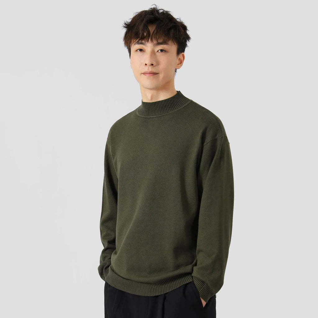 A man wearing a loose-fitting solid colour long sleeve casual pullover sweater.