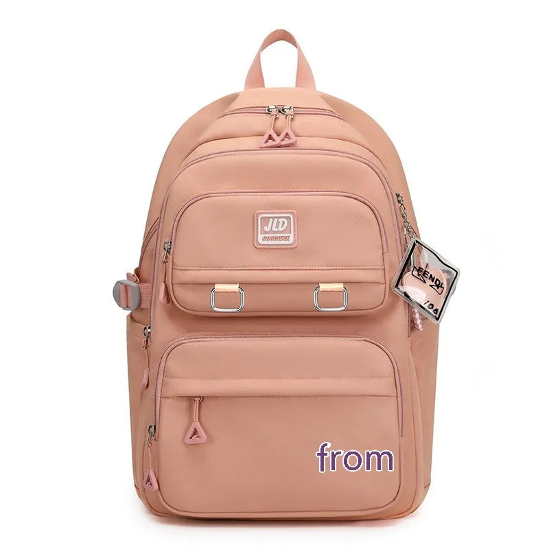 Girls' large purple nylon school backpack with a curved back panel, shown alongside blue and graphic print versions.