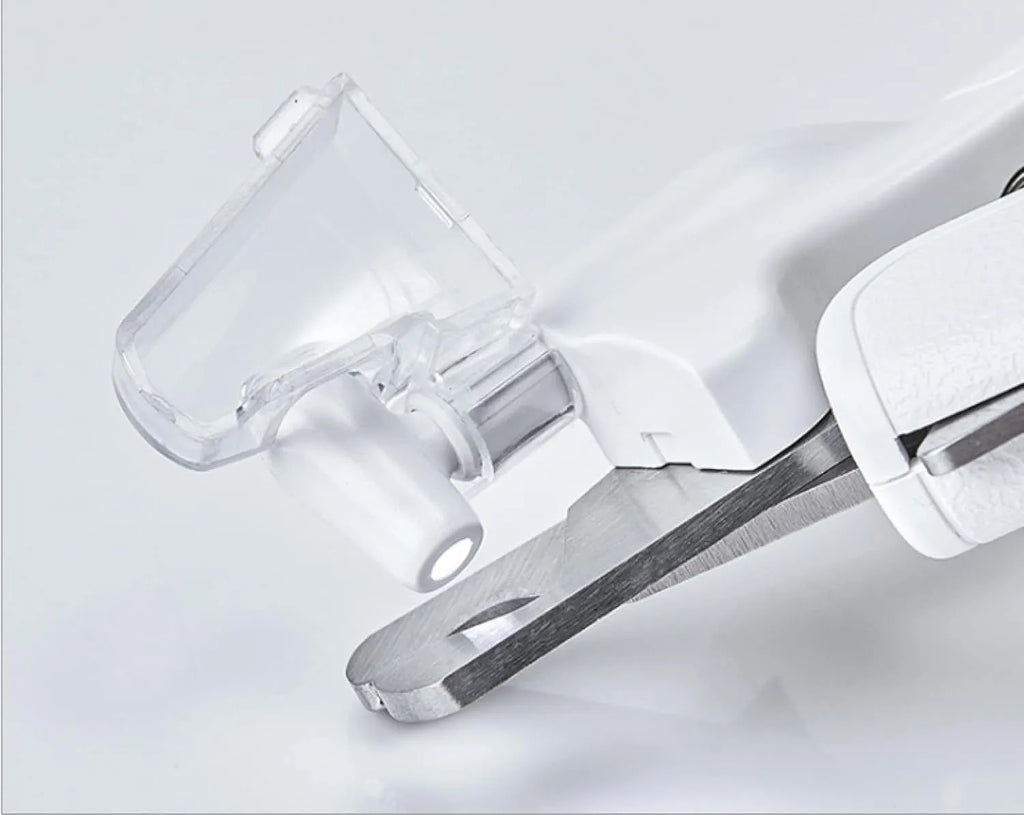 White pet nail clippers with LED light on blade and transparent anti-splash guard, shown with a nail file.
