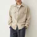 Men's light sand rice cotton lapel long sleeve shirt on a hanger.