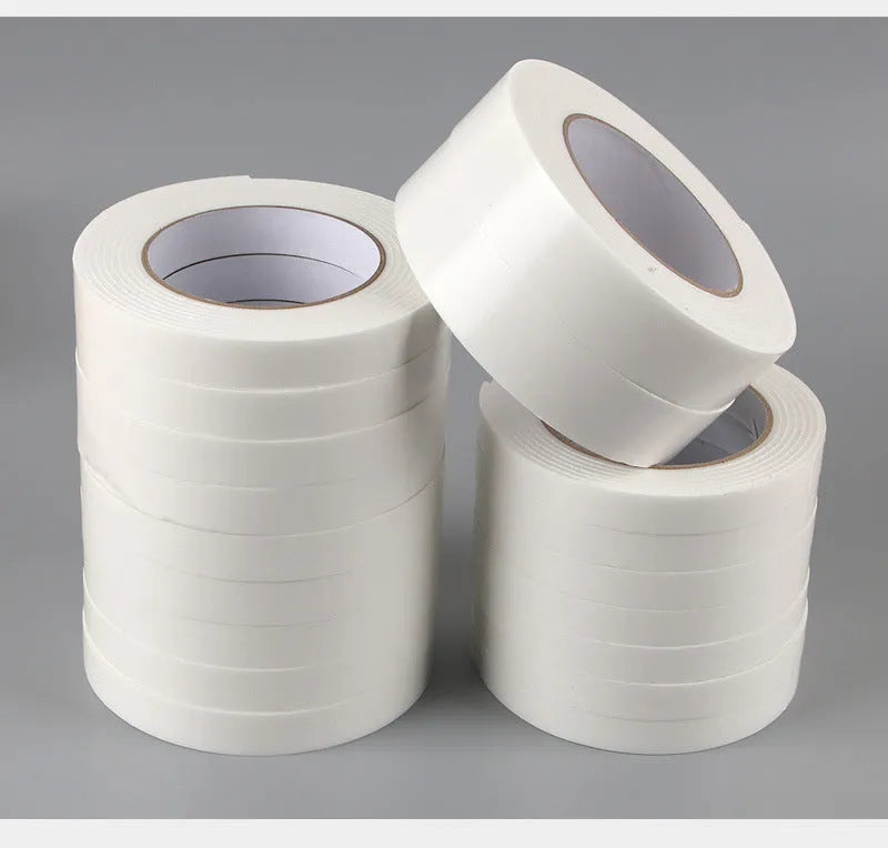 Roll of 3mm thick white foam double-sided adhesive tape showing its spongy core and strong adhesive on both sides.