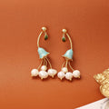 Natural baroque pearl ear studs with 14K real gold plated lily flower copper setting on white background