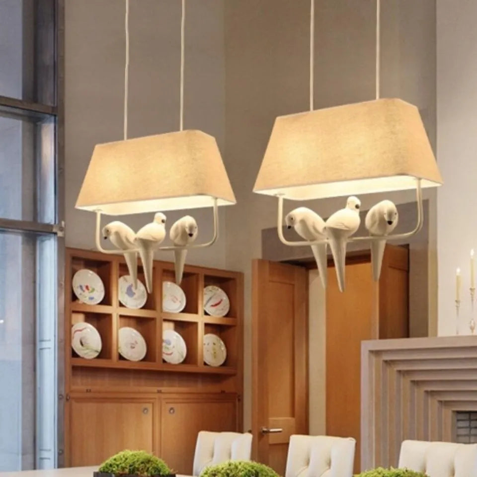 Iron ceiling chandelier with fabric shades featuring bird designs, hanging as a droplight.