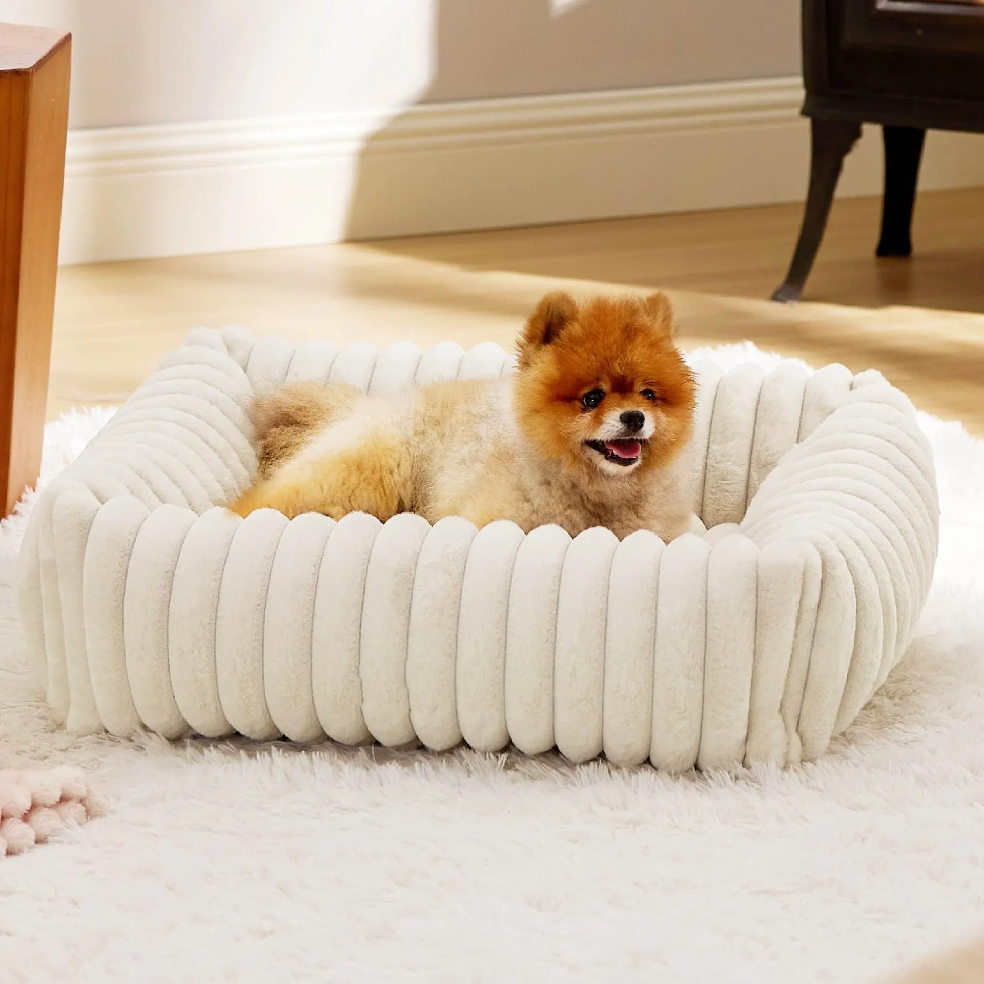 Beige removable cover pet bed for a medium-sized dog on a wooden floor.